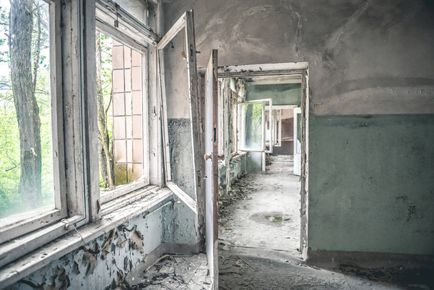 gloomy corridor with broken window frames and debris - Foto, imagen