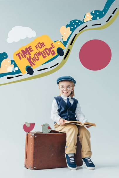smiling kid in retro vest and cap sitting on suitcase and holding book on grey background with car on road fairy illustration and time for knowledge lettering - Photo, Image