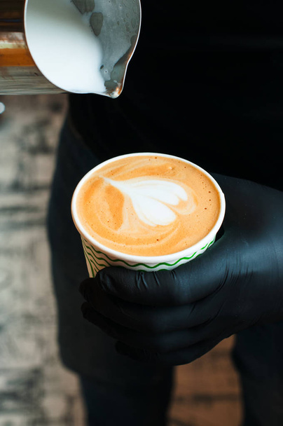 Barista pouring milk in coffee cup. Coffee art. - 写真・画像