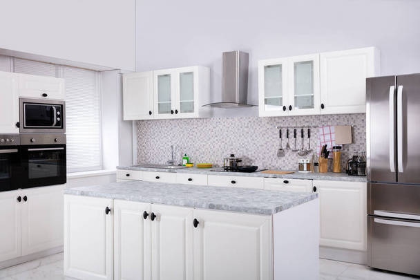 Interno della moderna cucina bianca pulita con forno a microonde e frigorifero
 - Foto, immagini
