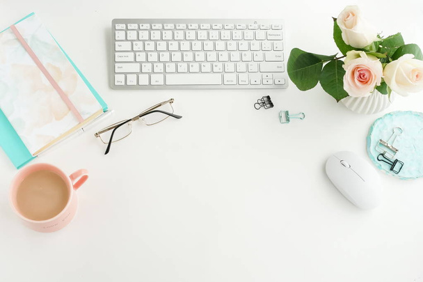 female workplace with arranged keyboard, cup of coffee and flowers - Zdjęcie, obraz