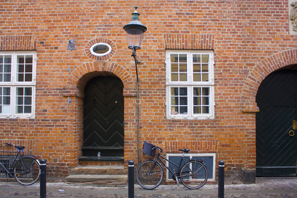  Parked bicycles near brick wall of building of Copenhagen, Denmark - Fotó, kép