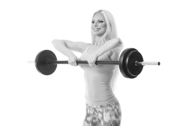 smiling sporty woman exercising with barbell - Photo, Image