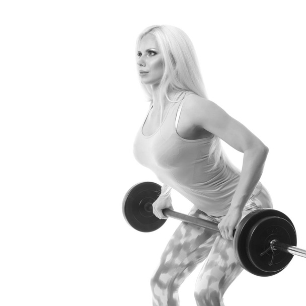 smiling sporty woman exercising with barbell - Photo, Image