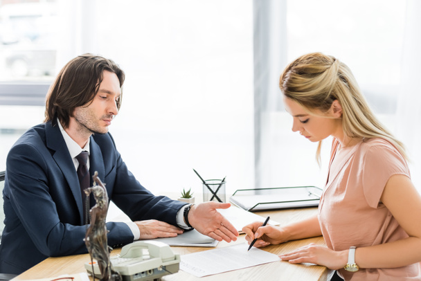 бізнесмен вказує рукою за контрактом під час підписання документа адвоката
 - Фото, зображення