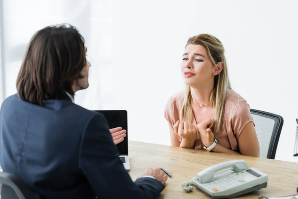 mujer frustrada sentada en la oficina y hablando con el hombre de negocios
 - Foto, Imagen