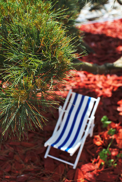 Іграшковий смугастий пляжний стілець для засмагання та відпочинку стоїть
 - Фото, зображення