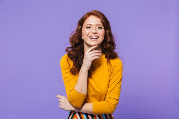 Portrait of a pretty young redheaded woman standing - Foto, imagen