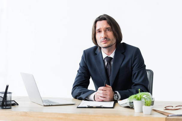 serious businessman sitting in office and looking at camera - Foto, Bild