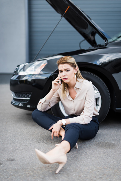 расстроена деловая женщина говорить на смартфоне рядом со сломанным авто, концепция страхования автомобиля
 - Фото, изображение