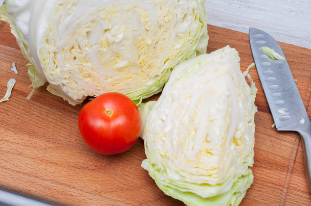 Composition with cut cabbage and tomato on wooden table. Healthy organic nutrition concept. - Fotoğraf, Görsel