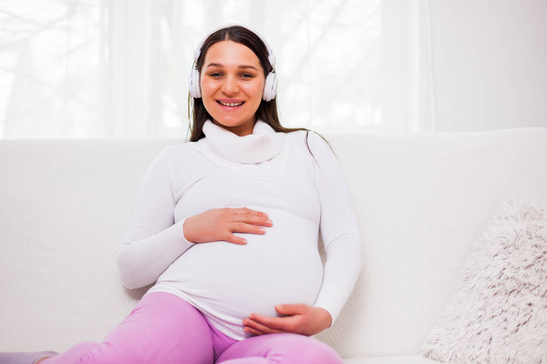 Boldog terhes nő pihentető otthon.  - Fotó, kép