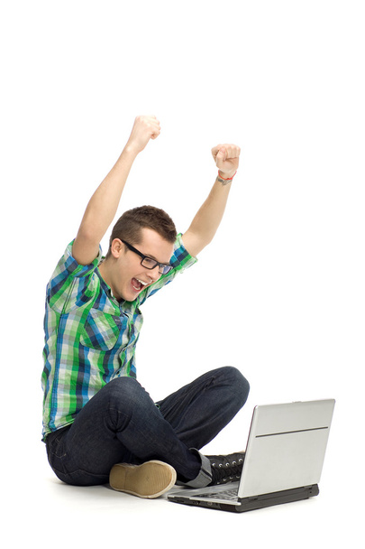 Guy using laptop with arms raised - Foto, immagini