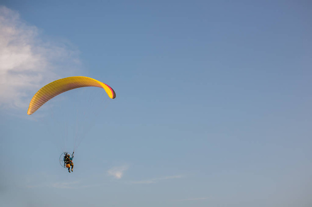 Silhouette of Paramotors flying to sky on sunset Adventure man active extreme sport pilot flying in sky with paramotor engine glider parachute. Paramotor flying on the sky at sunset.  - Φωτογραφία, εικόνα