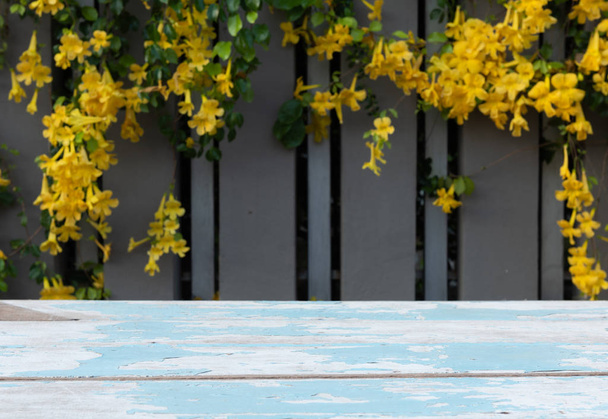Dřevěná stolní desky s krásnými žlutými květy a zelenou  - Fotografie, Obrázek