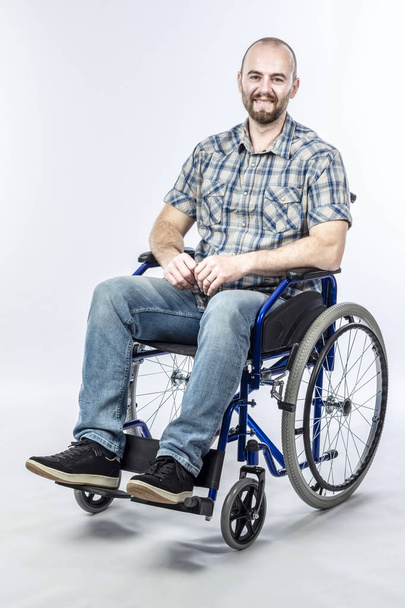 Smiling disabled man sitting in a wheelchair.  - Foto, Imagen