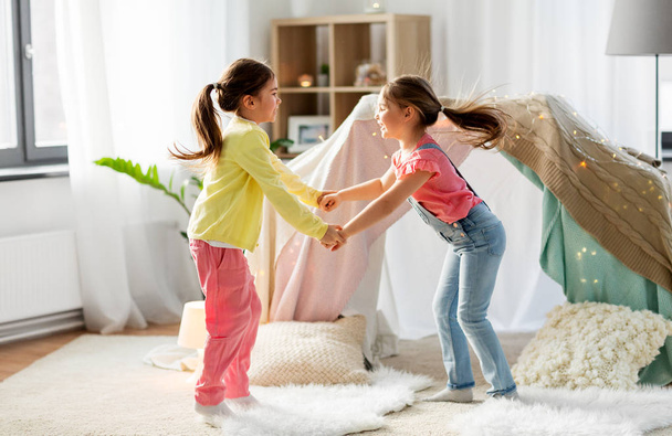 happy girls playing near kids tent at home - Zdjęcie, obraz