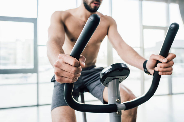 gedeeltelijke weergave van sportman training op elliptische machine in Gym - Foto, afbeelding