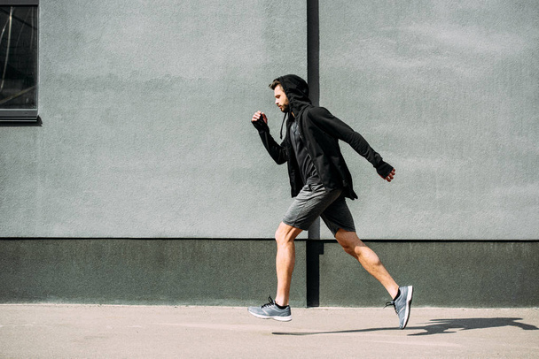side view of handsome sportsman running in sportswear - Valokuva, kuva