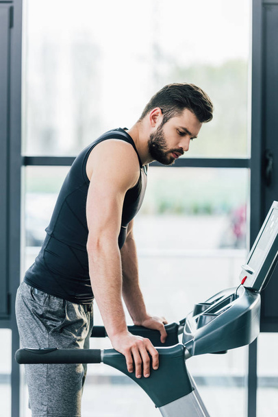 handsome sportsman training on treadmill at sports center - Photo, Image