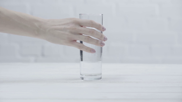 oříznutý pohled ženy, která si vezme sklenici vody na stůl  - Záběry, video