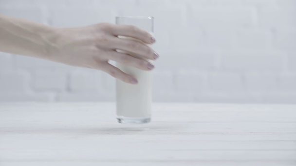 abgeschnittene Ansicht einer Frau, die ein Glas frische Milch nimmt - Filmmaterial, Video