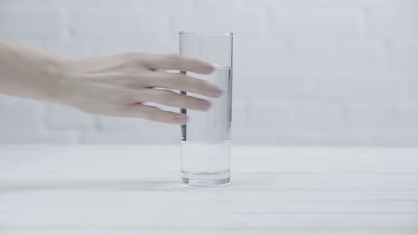 vista cortada da mulher colocando vidro de água na mesa
  - Filmagem, Vídeo