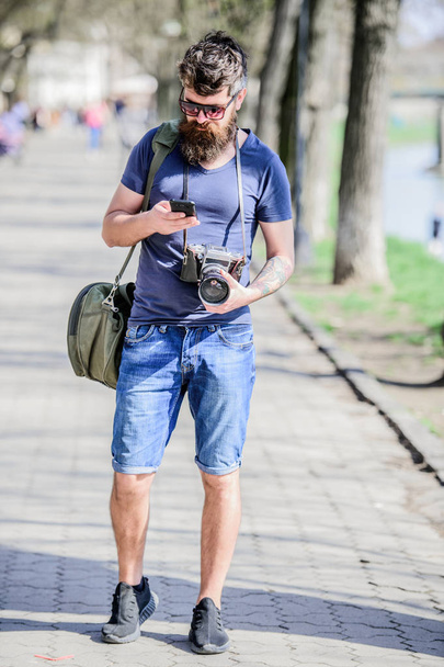 Photographer with beard and mustache. Tourist shooting photos. Content creator. Man bearded hipster photographer. Old but still good. Photographer hold vintage camera. Modern blogger. Manual settings - 写真・画像
