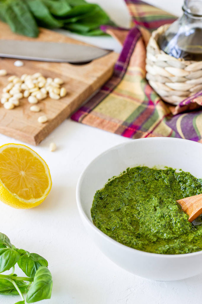 Pesto sauce and ingedients on a white background. Italian cuisine. Vegetarian food. The diet. - Фото, зображення