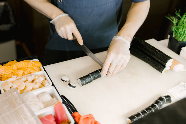 Sushi Master Corta Sushi com uma faca, Close, Cozinha Japonesa, Sushi Cooking
 - Foto, Imagem