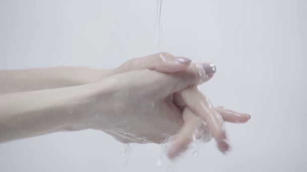 przycięte widok kobiety mycia rąk podczas wody nalewanie na szarym  - Materiał filmowy, wideo
