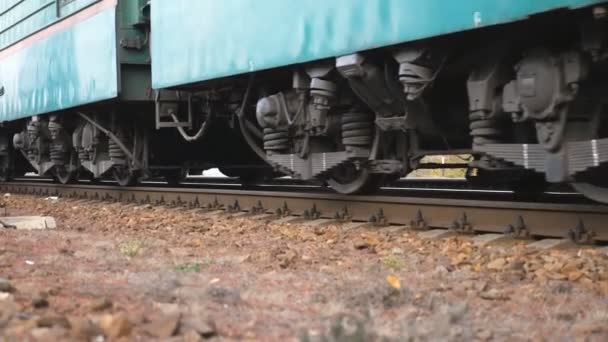 Nahaufnahme der sich drehenden Stahlräder des Zuges, der sich auf den Gleisen bewegt. Ein Personenzug fährt an einer Kamera vorbei. Transport- und Reisekonzept. Niedrige Blickwinkel Zeitlupe - Filmmaterial, Video