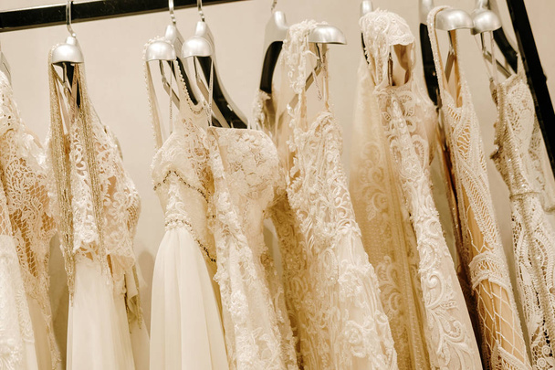 Vestidos de novia de crema colgando en el estante - Foto, Imagen