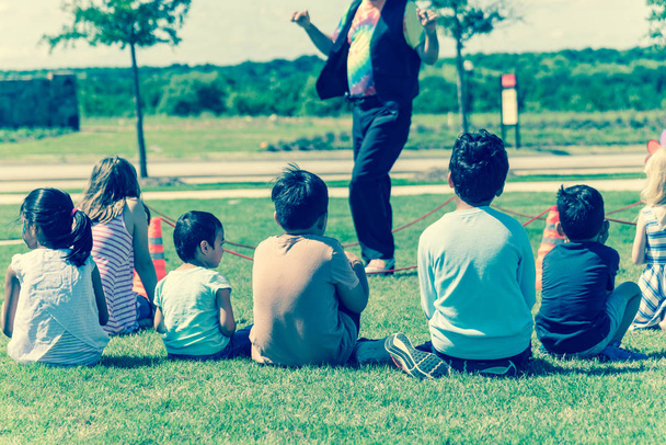 Image filtrée close-up vue arrière enfants multiculturels sur herbe prairie de jeu en plein air
 - Photo, image
