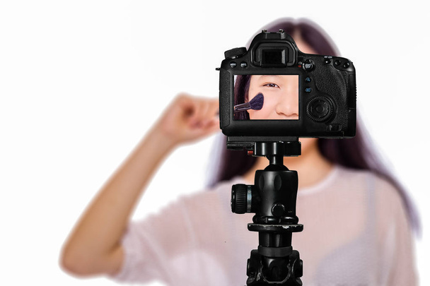 Εστίαση σε ζωντανή προβολή στην κάμερα σε τρίποδο, έφηβο κορίτσι με θαμπάδα - Φωτογραφία, εικόνα