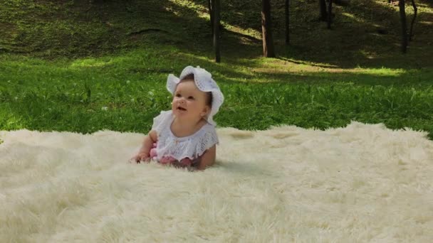 Velmi malá a krásná dívka, která si hrála na posteli v parku. - Záběry, video