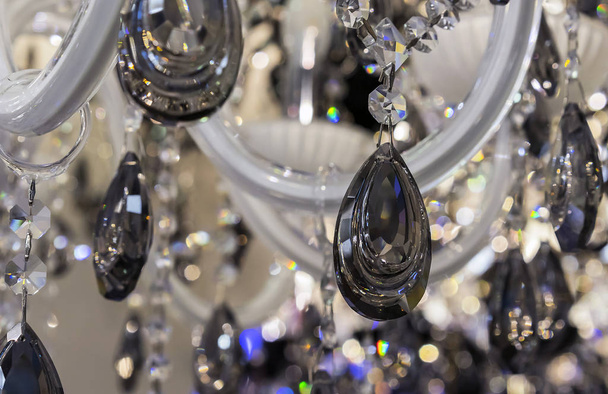 Black crystal pendants on a classic chandelier. - Zdjęcie, obraz