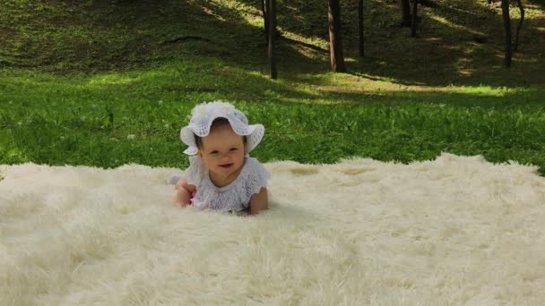 Velmi malá a krásná dívka, která si hrála na posteli v parku. - Záběry, video