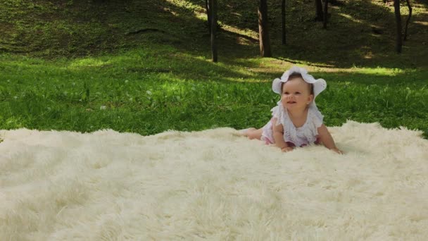 A very small and beautiful girl playing on the bedspread in the park. - Footage, Video