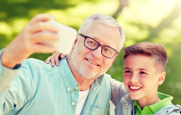 old man and boy taking selfie by smartphone - Photo, Image