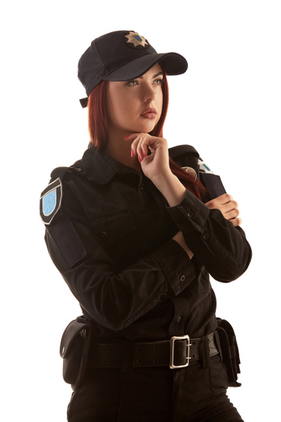 Mujer policía pelirroja posando para la cámara aislada sobre fondo blanco
. - Foto, Imagen