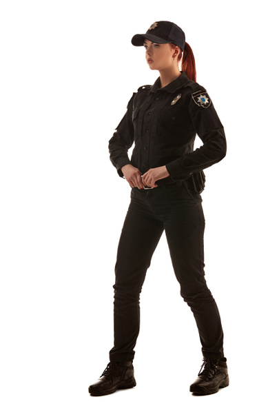Ganzkörperaufnahme einer rothaarigen Polizistin, die isoliert auf weißem Hintergrund für die Kamera posiert. - Foto, Bild