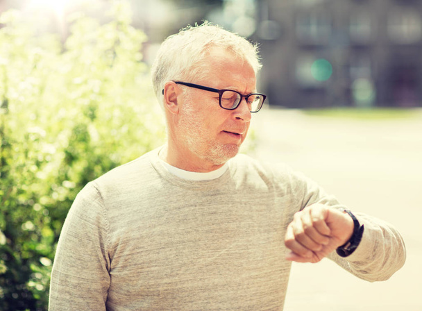 senior man checking time on his wristwatch - Zdjęcie, obraz