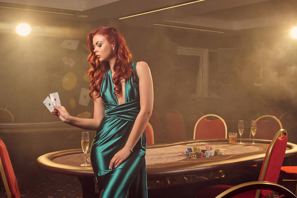 Молода красива жінка позує на покерний стіл в розкішному казино
. - Фото, зображення