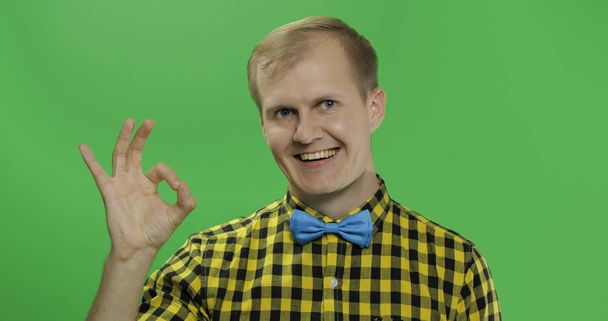 Hombre caucásico con camisa amarilla mostrando buen gesto. Clave de croma
 - Foto, Imagen