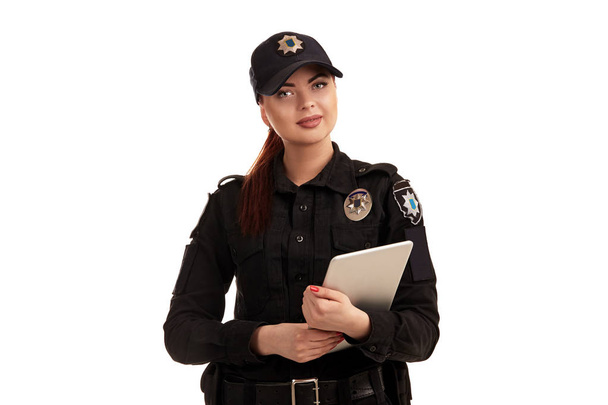 白い背景に隔離されたカメラのためにポーズをとる赤毛の女性警官のクローズアップショット. - 写真・画像