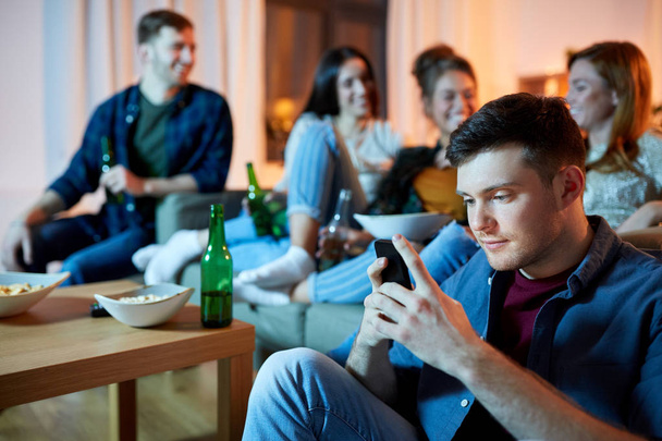 man with smartphone at home party - Photo, Image