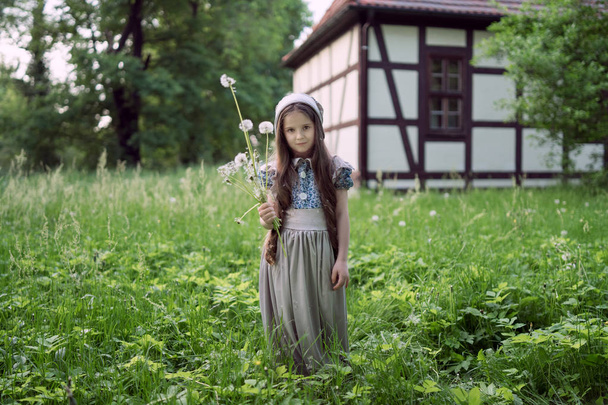 The girl in a dress in retro style with dandelions. - Fotó, kép