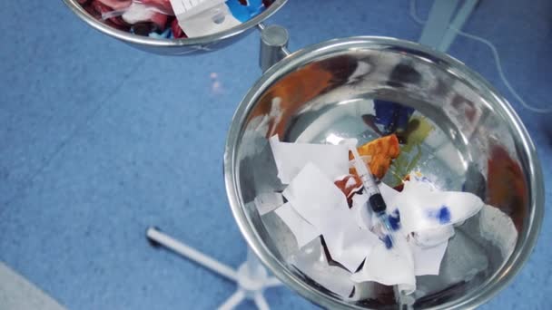 seringas usadas e ligaduras em uma lata de lixo em um hospital cirúrgico
 - Filmagem, Vídeo
