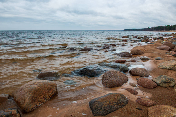 Einsamer leerer Meeresstrand mit weißem Sand, großen Felsen und altem Holz - Foto, Bild